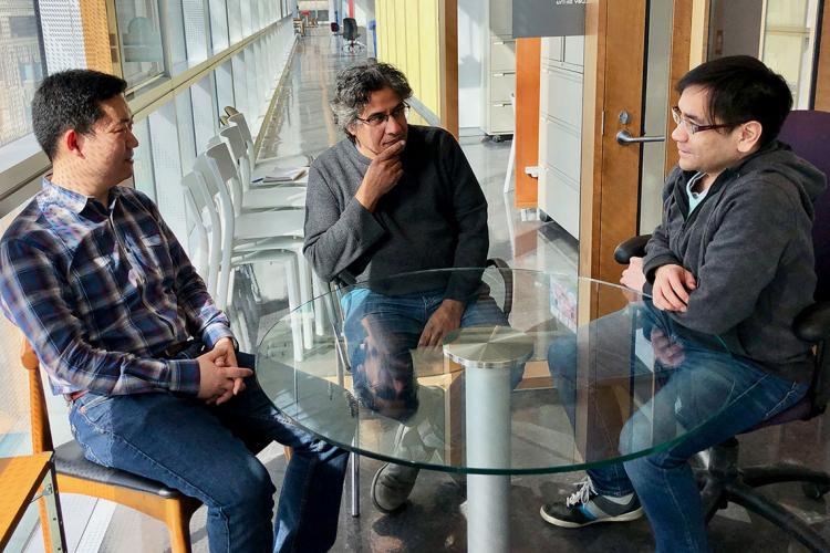 U of T researchers Sachdev Sidhu, Wei Zhang and Jacky Chung sit around a table