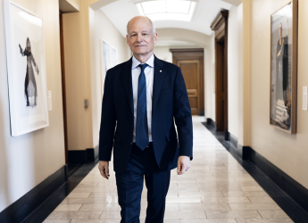 President Meric Gertler walks down a hallway