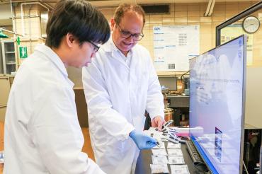 PhD candidate Yu-Chen (Gary) Sun and Professor Hani Naguib hold a glove made with smart materials in a laboratory