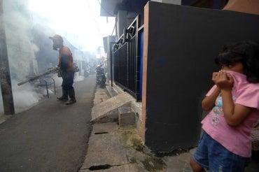 photo of little girl trying to avoid inhaling the spray for Zika-carrying mosquitos