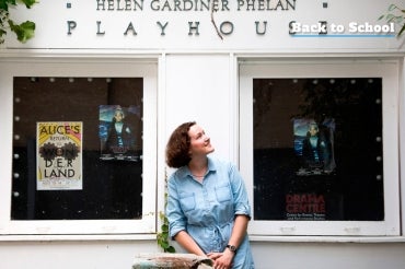 Marie Trotter sitting on a bench outside the Helen Gardener Phelan Playhouse