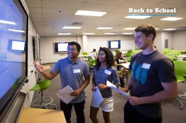 Photo of engineering students looking at a video screen in newly renovated classroom