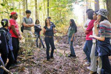 photo of professor and students in forest