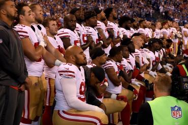 photo of football players taking a knee