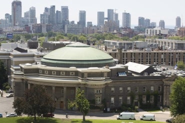 Photo of U of T against background of Toronto skyline