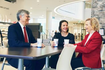 Norman Loveland, Amanda Carling and Gay Loveland sitting at table talking with coffee