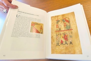 photo of Cohen's book, held open to show illustration of illuminated manuscript