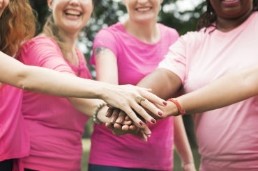 Photo of women in pink giving each other support