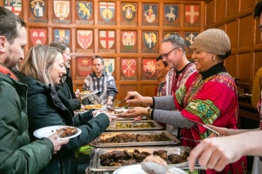 A volunteer serves food to attendees at the Black History Month Luncheon at Hart House in 2020