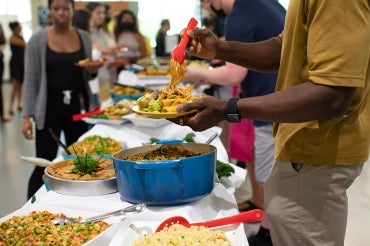 A student piles his plate high with plant based food from the buffet being served at a workshop focused on cooking plant-based food