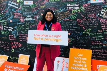 Anjum Sultana pictured at the UN holding a sign saying "Education is a right. Not a privilege"