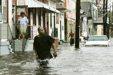 A man walks down a flooded street in New Orleans after Hurricane Katrina