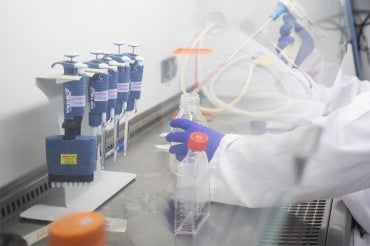 Person working under a fume hood in a laboratory at U of T