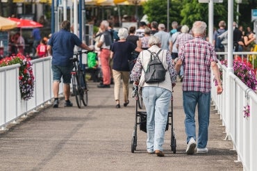 Two seniors walking across a bridge