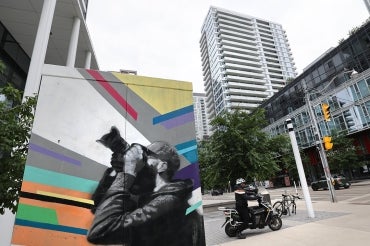 Regent park neighbourhood in downtown Toronto with public art in the foreground