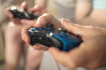 two young men holding video game controllers