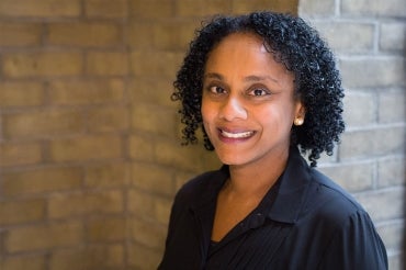 Lisa Robinson stands in front of a brick wall