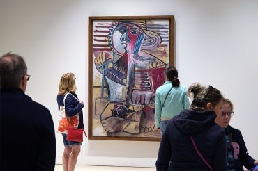 Art gallery patrons look at Picasso's Child with a Shovel at the Picasso Museum in Malaga Andalusia