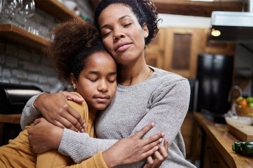 A mother consoles her adolesent daughter 