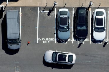 An overhead view of electric vehicles and designated spaces in a parking lot