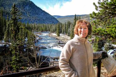 photo of Marilyn Smith with a river, mountains and trees in the background