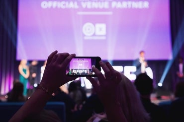 an attendee takes a photo of the main stage at the elevate ai festival in 2018