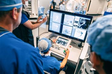 A surgeon at the controls of the robot conducting the procedure