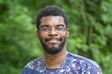 Photo of Philip Asare wearing a purple T-shirt