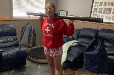 Brenna Hamel weightlifting at home using a pipe and backpacks