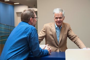 Chris McCulloch sits at a table with a colleague