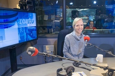 Christine Allen sits in front of a microphone in the CBC studio