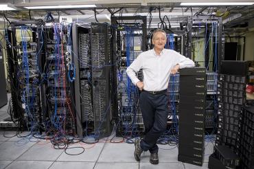 Geoffrey Hinton stands in a room of servers