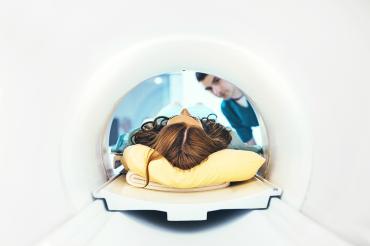 a technician helps a woman into an MRI machine