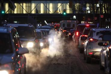 Cars and trucks creep bumper to bumper along a Toronto down street on a winter night