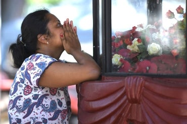 Woman praying after Sri Lanka attack