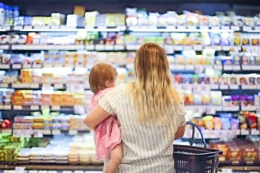 Woman holding a small child at a grocery store