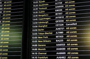 Photo of a flight information board at an airport showing a cancelled flight to Shanghai