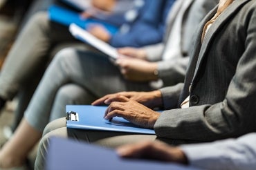 a row of job applicants wait nervously