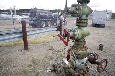 Chained up natural gas wellhead with valves, Northern British Columbia, Canada.