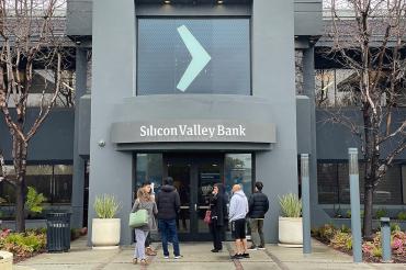 people wait outside a branch of Silicon Valley Bank