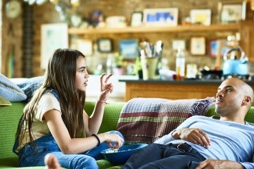 A father and daughter talking on a sofa