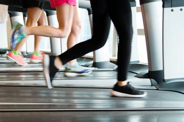 Waist-down photo of people exercising on treadmills