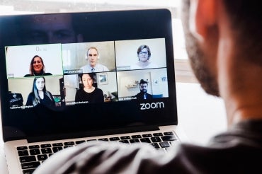 Three Minute Thesis participants appear on a laptop screen