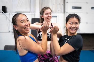 Three members of the UTSC cheer club share at laugh 