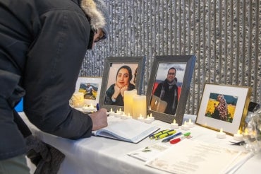 Mourner signs a book of condolences at a vigil for the victims of Flight 752