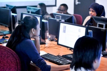 students looking at computer screens in a computer lab