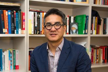 Portrait of Joe Wong in front of a bookshelf