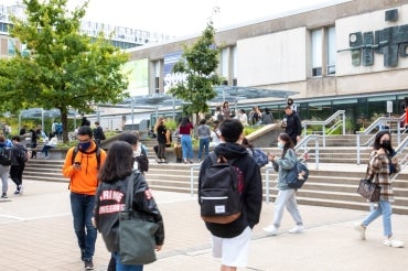 Students walk past the front entrance of Sidney Smith Hall