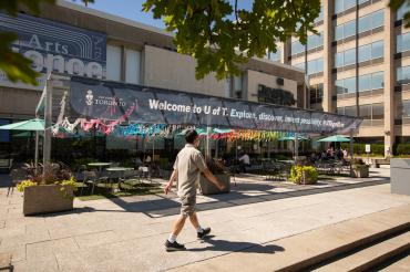 a student walks in front of Sidney Smith Hall