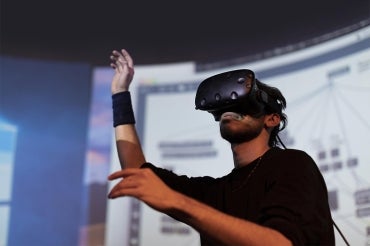 A man using VR goggles in a darkened room